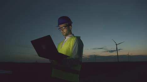 engineer working on wind turbine maintenance at night