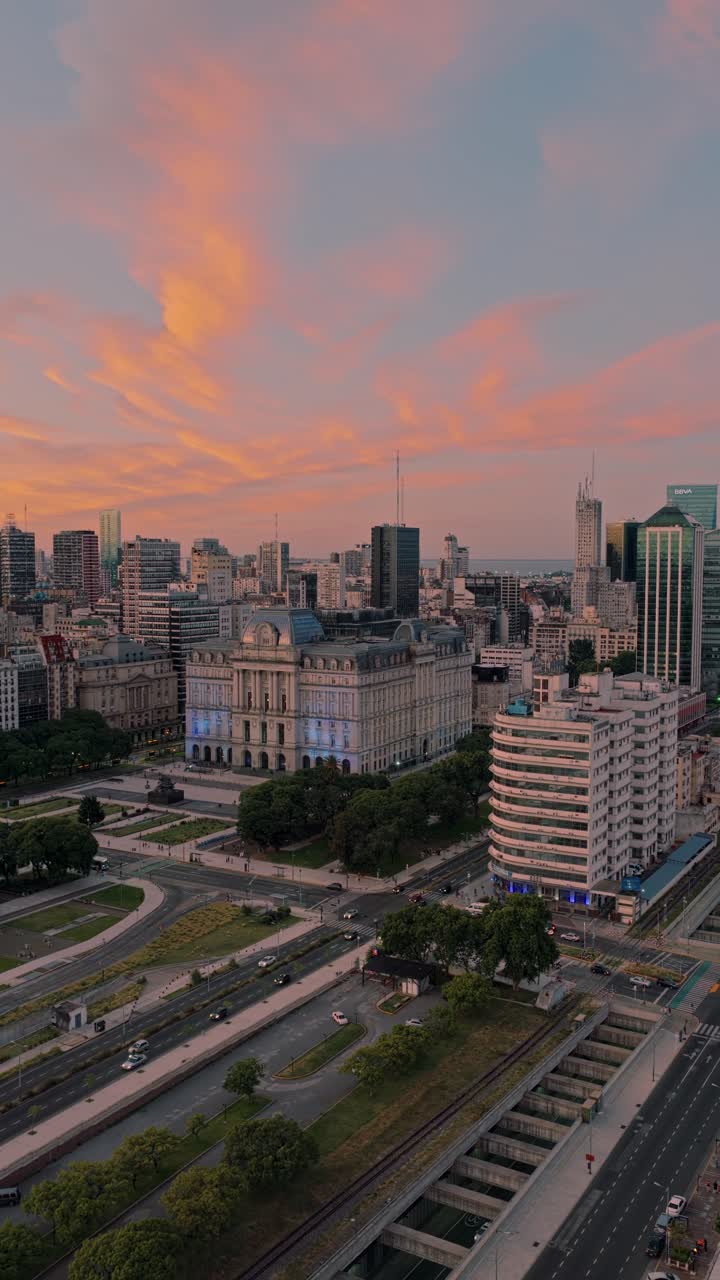 Vertical aerial pan right revealing Palacio Libertad, former CCK, surrounded by downtown Buenos Aires architecture during sunset and warm evening light