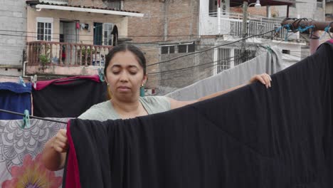 Adult-Hispanic-woman-on-the-terrace-of-her-house-in-poor-neighborhood-in-Tegucigalpa,-Honduras