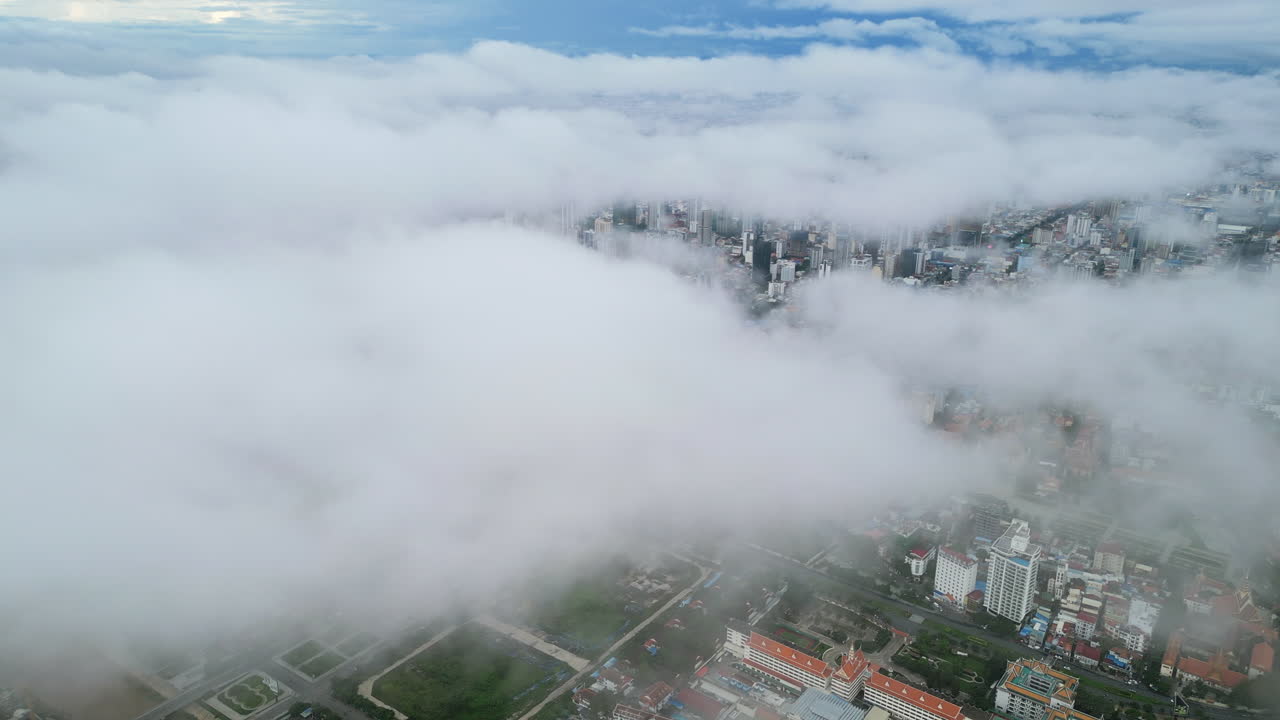Aerial video of Phnom Penh shows clouds drifting low over the city, hiding buildings beneath soft fog