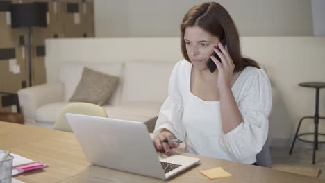 focused manager talking on mobile phone and writing note