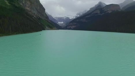 aerial views over turquoise louise lake in rockies mountains, banff national park, alberta, canada