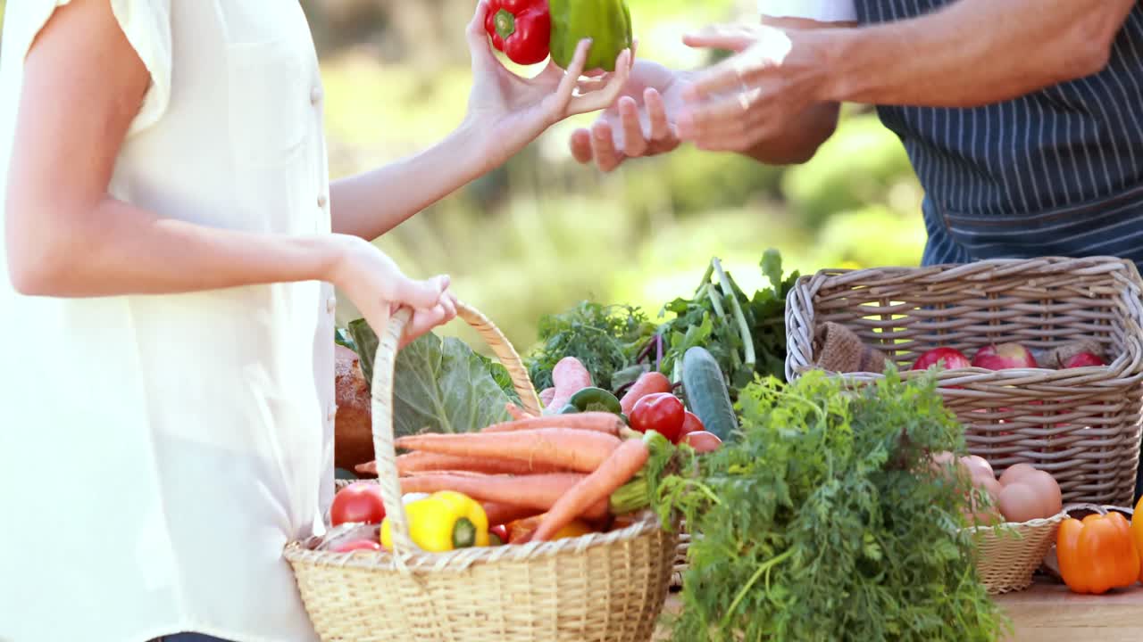 미소 짓는 농부 가 금발 의 고객 과 토론 하고 있다