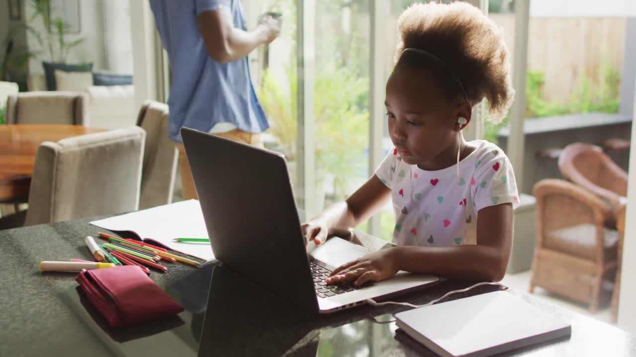 video de padre e hija afroamericanos usando una computadora portátil y aprendiendo