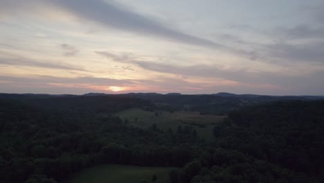 Eine-Drohnenaufnahme-Einer-Atemberaubenden-Aussicht-Auf-Bunte-Wolken-Und-Geschichtete-Berge-Bei-Sonnenuntergang