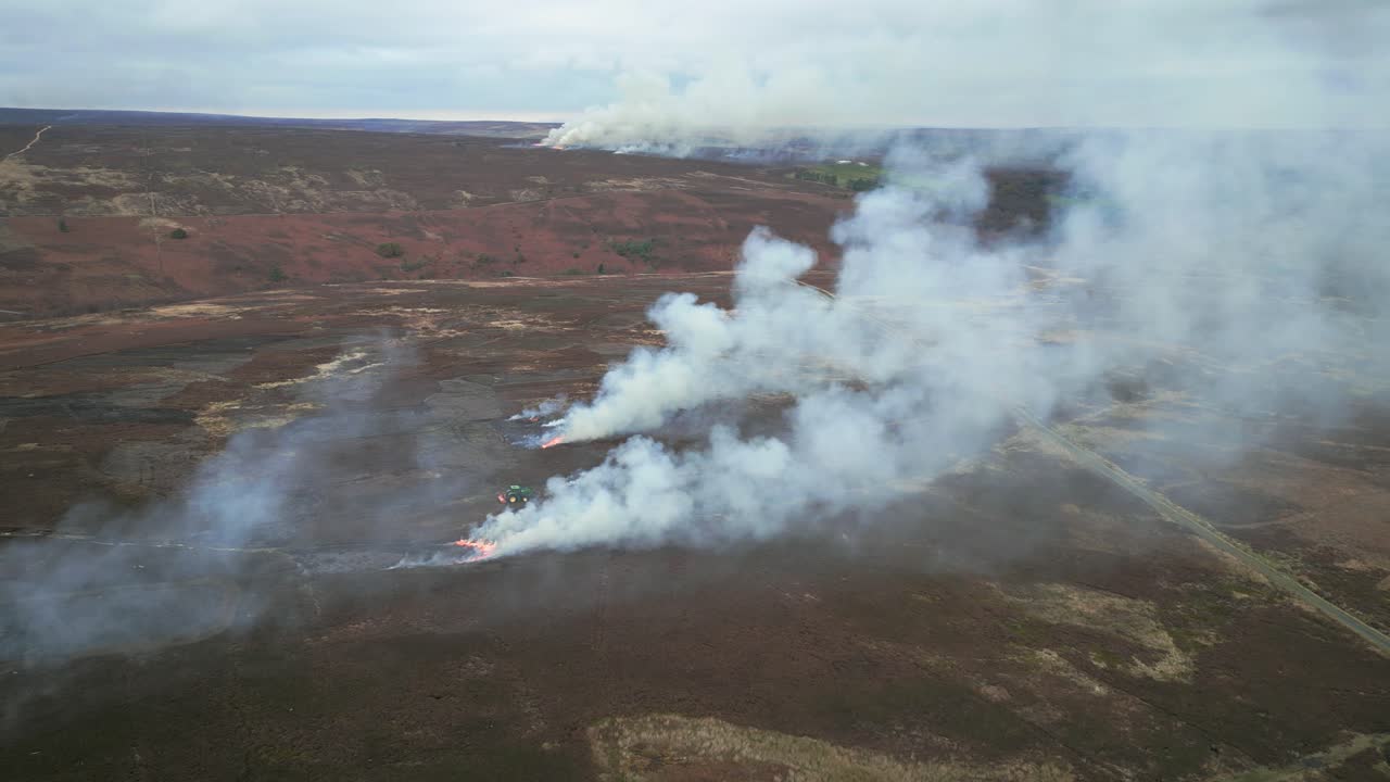 Smoke rising from controlled burning of heather on the North York Moors.Low level aerial from drone.