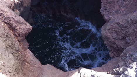 waves crashing into a coastal rock hole