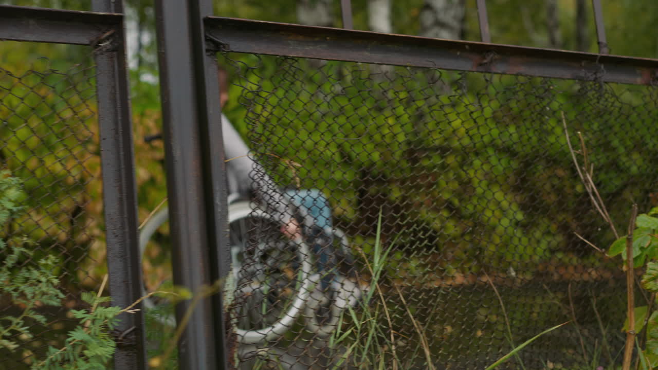 체어 에 앉은 여자 가 병원 의 오래된 울타리 근처 에 이동 한다