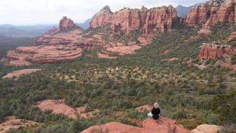 woman meditating on the edge of mountain, red rocks, sedona, arizona