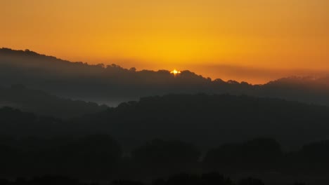 Timelapse-of-a-golden-orange-sunrise-over-lush-hills-in-La-Vall