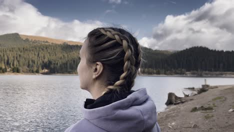 lone woman looking at the peaceful nature of bolboci lake in romania