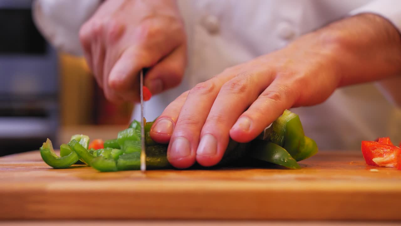 el cocinero está cortando pimientos verdes