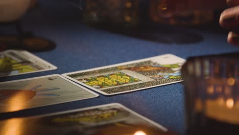 Close-Up-Of-Woman-Giving-Tarot-Card-Reading-On-Candlelit-Table-5