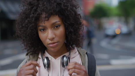 portrait of stylish african american woman looking calm pensive at camera young black female student in urban city background real people series