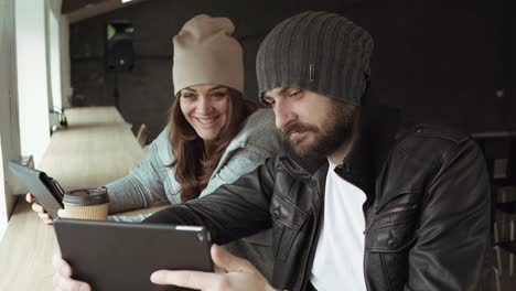 Work-meeting-in-creative-office.-Young-man-and-woman-using-a-tablet-to-watch-video.-Shot-in-4k