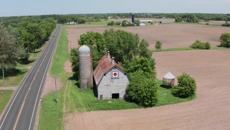 Toma-Panorámica-Aérea-De-Un-Antiguo-Granero-Y-Silo-En-Las-Tierras-Rurales-De-Minnesota