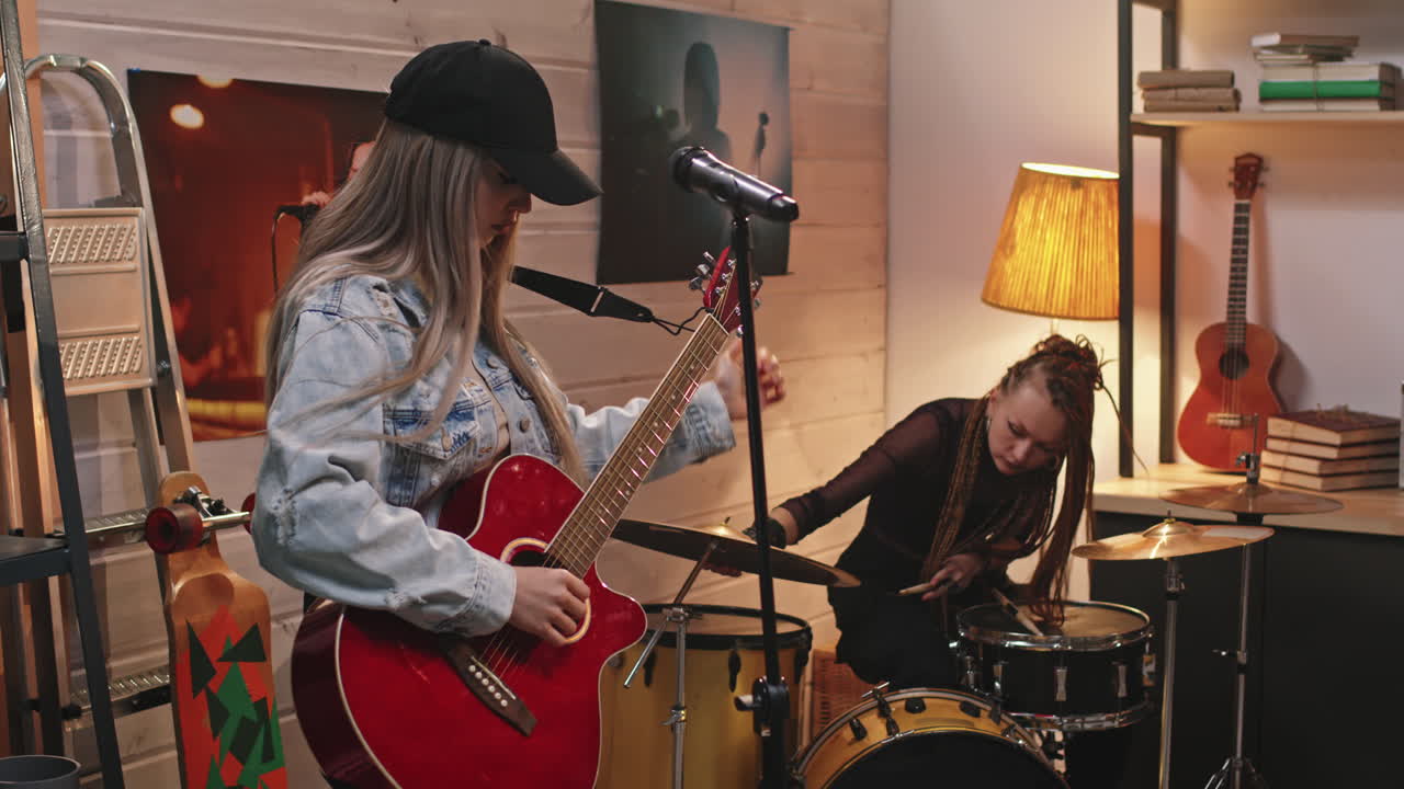 Female Guitarist And Drummer Preparing For Concert
