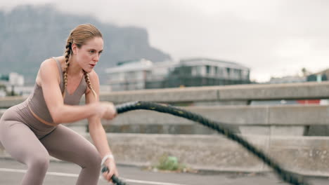 mujer haciendo ejercicio con cuerdas de batalla al aire libre