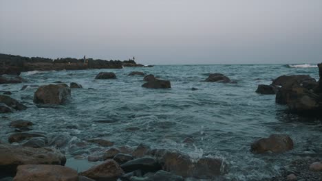 strong waves on the beach with rock cliff and stormy waves