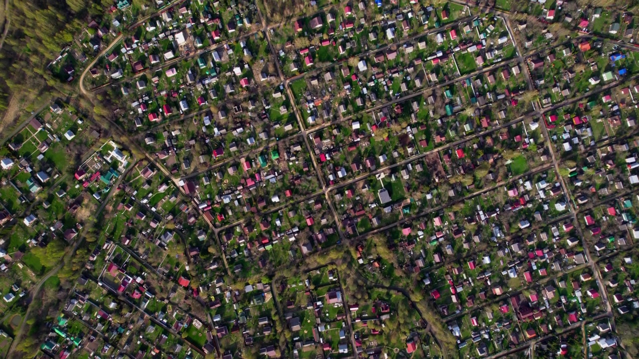 Vista verticale da drone che mappa una fitta griglia di villaggi rurali con orti, piccole strade, tetti colorati e alberi, per la pianificazione territoriale, i modelli residenziali e i temi di campagna.