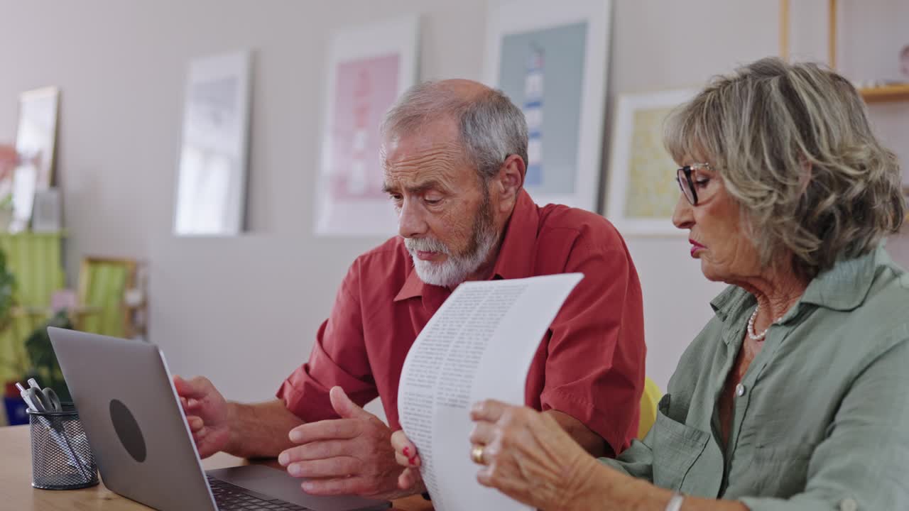 Senior couple reviewing finances on laptop