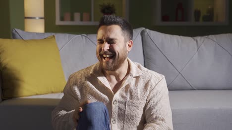 The-schizophrenic-man-sitting-alone-at-home-starts-laughing-to-himself.