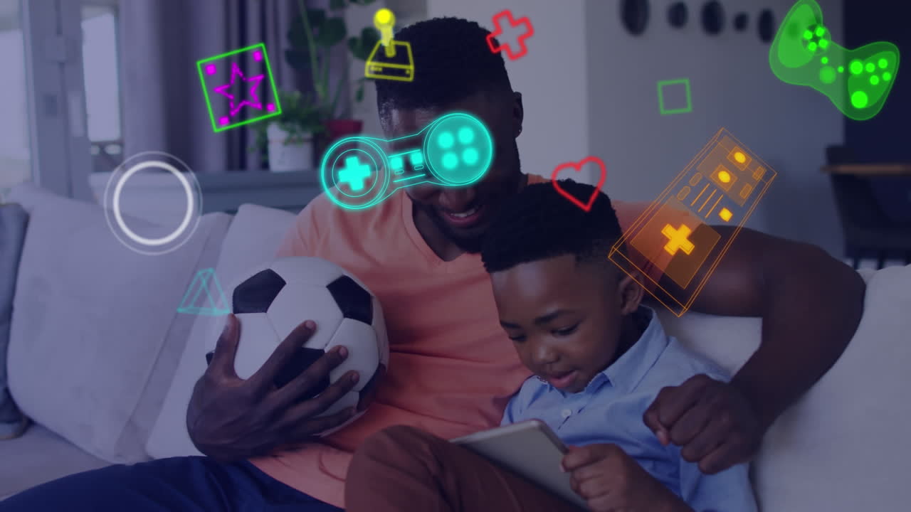 Animation of game media icons over smiling father and son using tablet on couch at home
