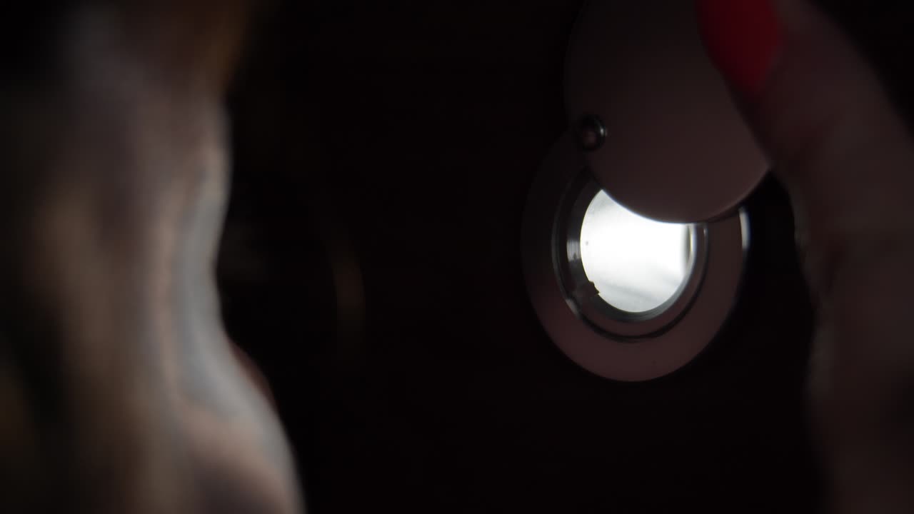 걱정스러운 여자가 저녁에 구을 통해 눈을 가까이 쳐다보고 있습니다.