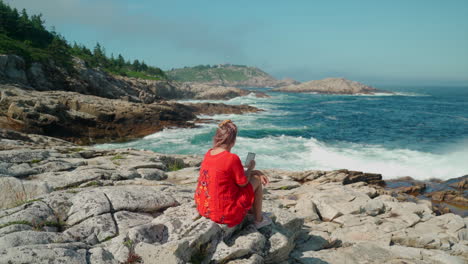 Mujer-Vestida-De-Rojo-Mirando-La-Costa-Este-De-Canadá-Durante-El-Día