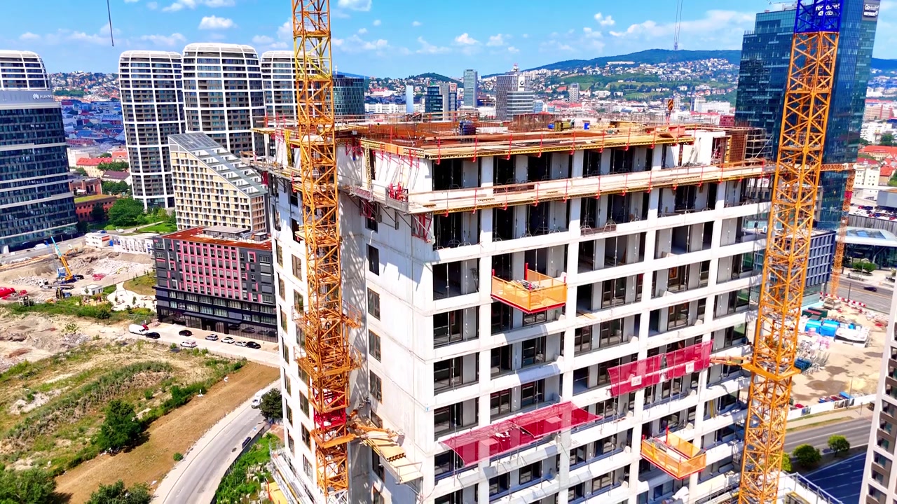 Bratislava, Slovacchia, 2 giugno 2026: Cima di edificio in cemento, Bratislava, Slovacchia. Ripresa elevata con drone di una gru edile gialla sulla facciata di una torre a molti piani sotto la luce solare limpida