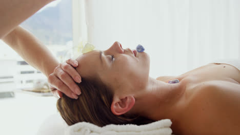terapeuta sosteniendo una vela por encima de su paciente