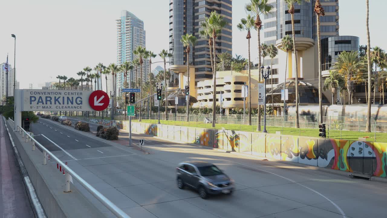 tomada fija de 4k: mirando más allá de la señal de estacionamiento del centro de convenciones de san diego, un tranvía de tren que pasa por el barrio de gaslamp, septiembre de 2023