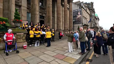 coro cantando en la calle, la multitud se reúne