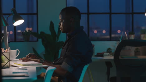 young african american businessman using computer working late night successful entrepreneur busy on company project dedicated black male in start up office workspace