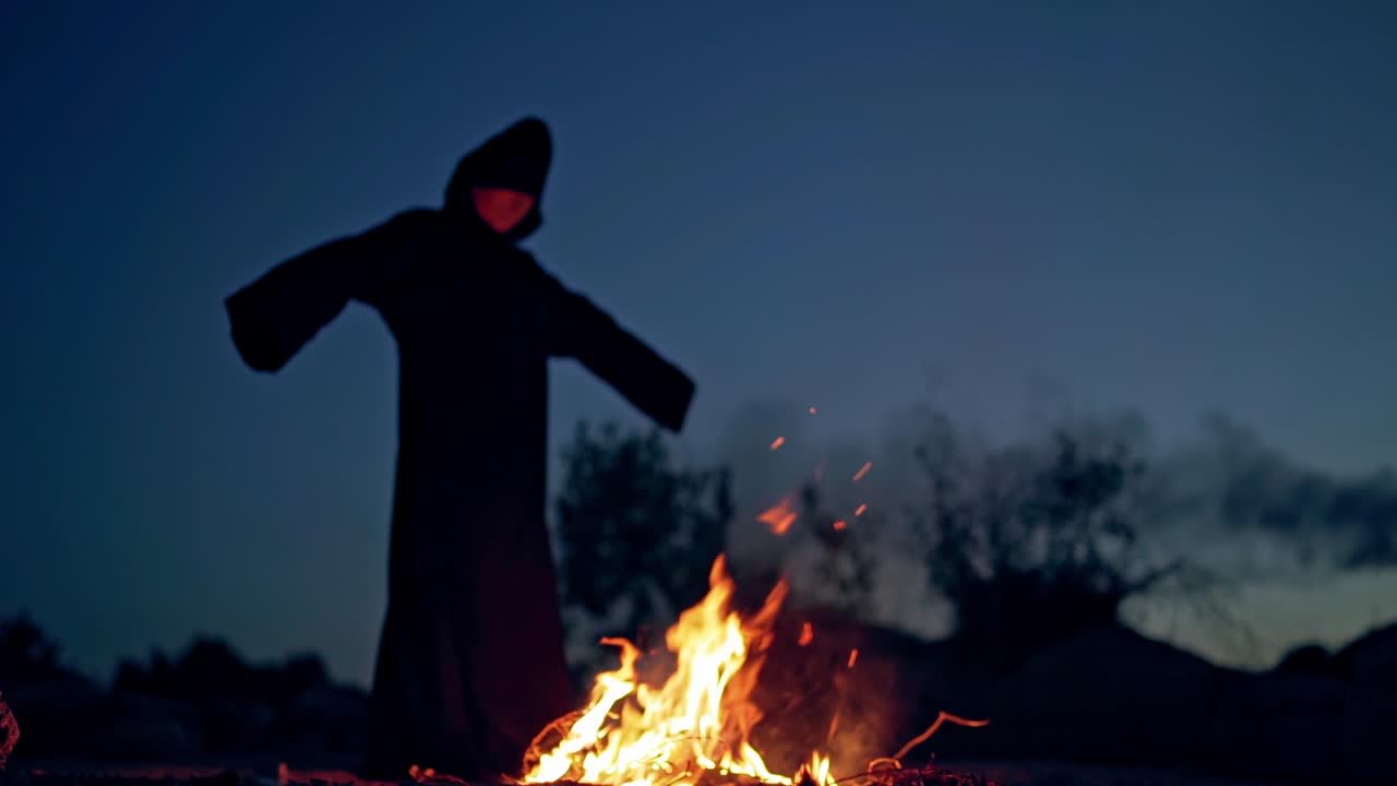 Witch bonfire place. Witch performs ritual near bonfire at night