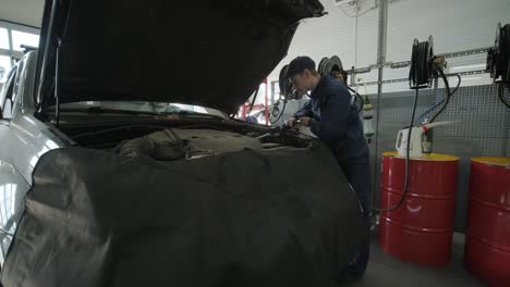 auto mechanic changing car oil in workshop