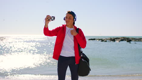 Beach,-smartphone-and-man-with-headphones