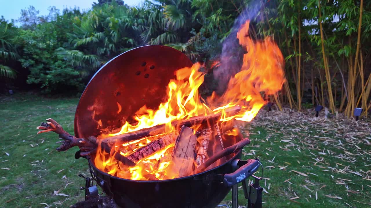 하루가 끝날 무렵에 밖의 정원에서 인상적인 바베큐 불꽃, 프랑스
