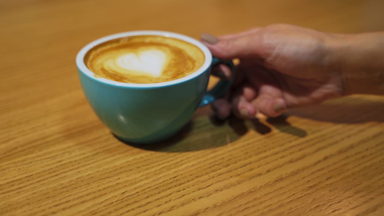 Coffee in small cup. Coffee cup with milk on table in cafe