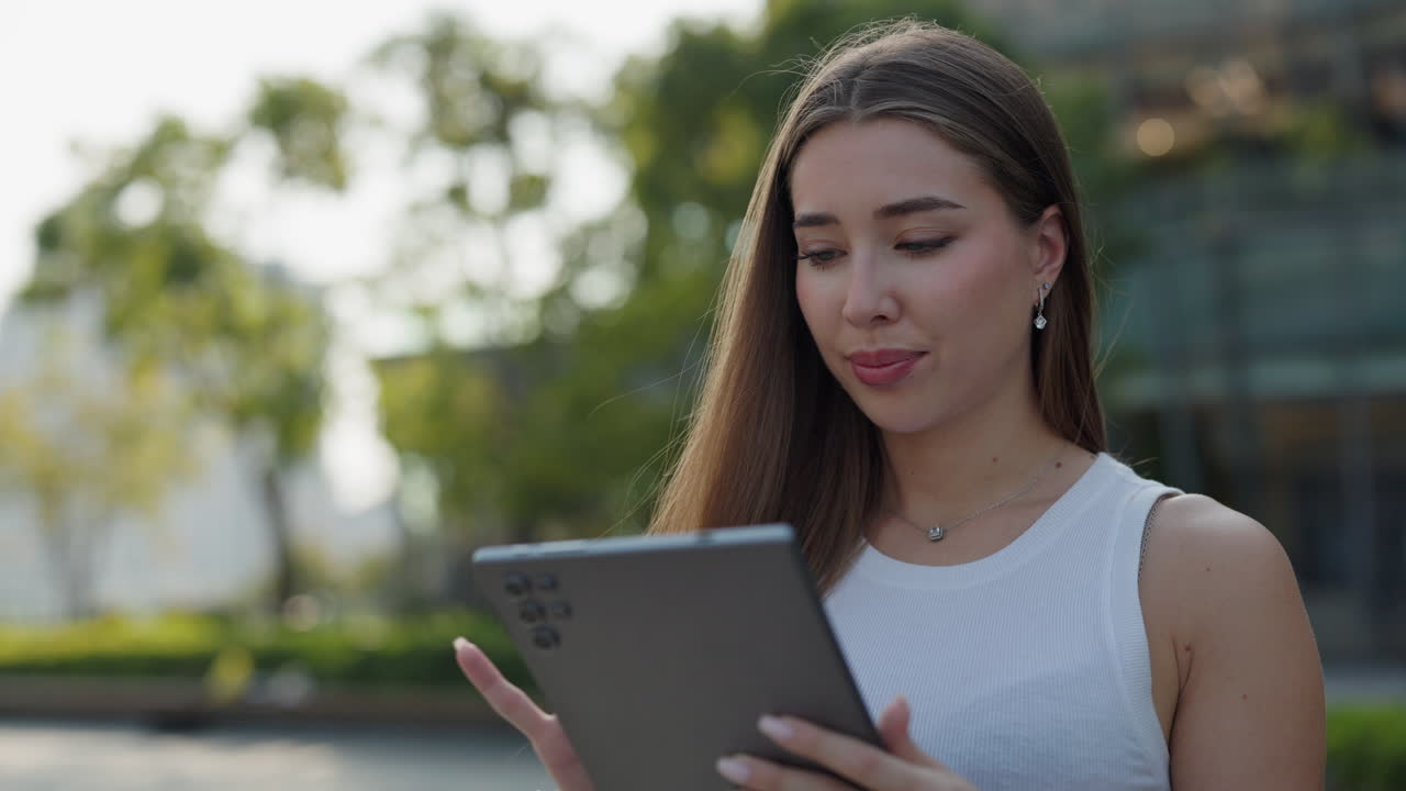 женщина, использующая планшет на открытом воздухе
