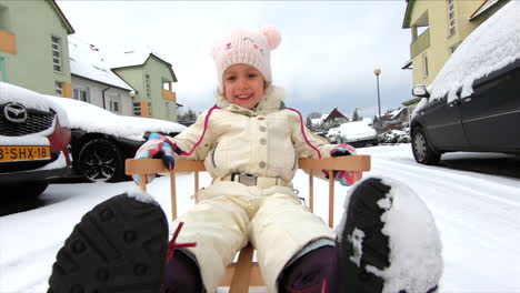 a little girl is on a snow sleigh