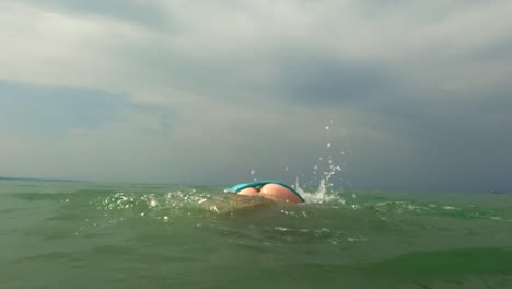 Young-kid-girl-has-fun-with-somersault-in-ocean-water-with-diving-mask