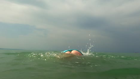 young kid girl has fun with somersault in ocean water with diving mask