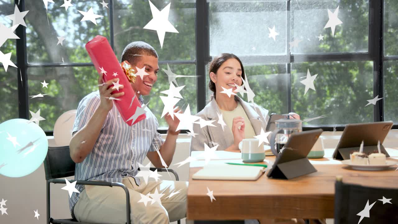 Male coworker opening red gift after coworker handing it in office, star overlay celebrating
