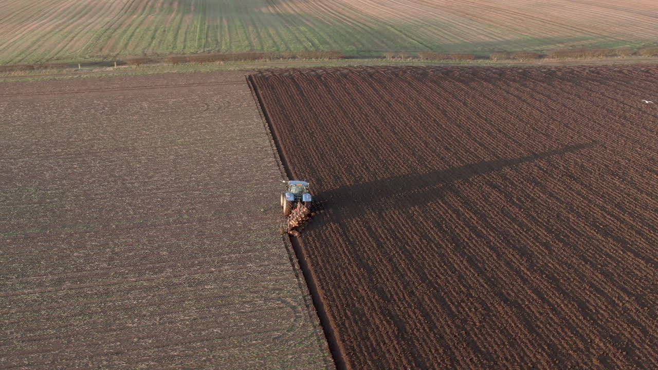 Vista aerea di un trattore agricolo che ara un campo ad Aberdeenshire in una giornata di sole, Scozia