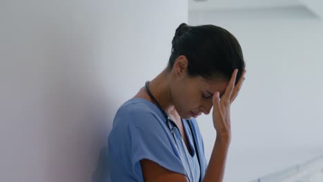 Sad-female-surgeon-standing-in-corridor