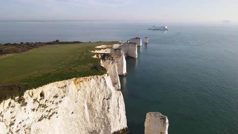 Luftaufnahme-Nach-Vorne-über-Weiße-Und-Zerklüftete-Klippen-Der-Alten-Harry-Rocks-Und-Kreuzfahrtschiff-Im-Hintergrund,-Purbeck-Island,-Dorset