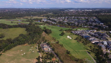 high drone aerial shot of australian residential suburb large houses golf course - colebee nsw