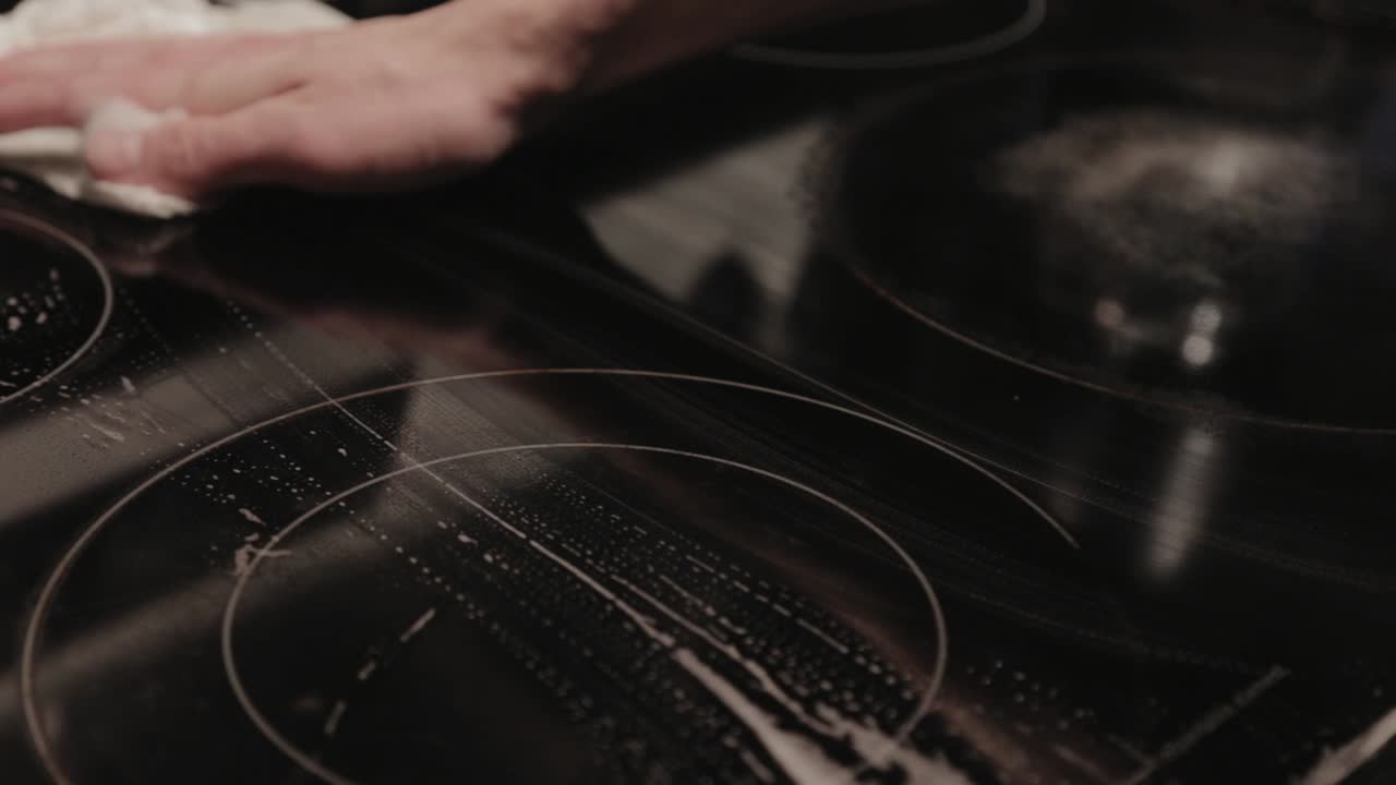 Wiping Off The Soapsuds From The Top Surface Of Electric Induction Convection Range - Close Up Shot