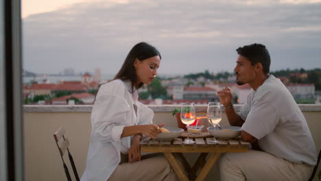 happy couple giving five at sunset terrace. newlyweds speaking on anniversary